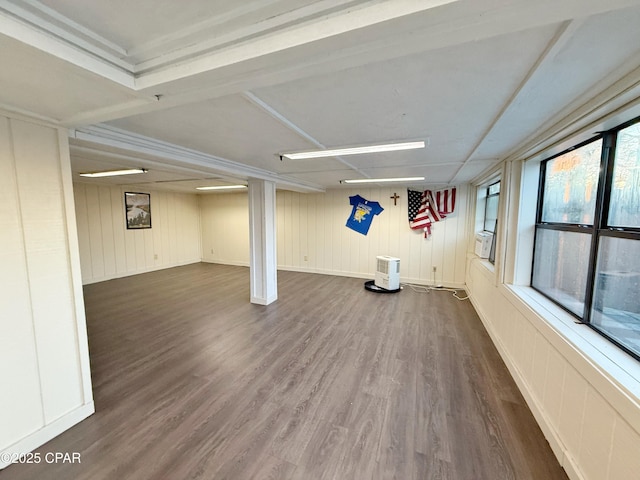 basement featuring baseboards and dark wood-type flooring