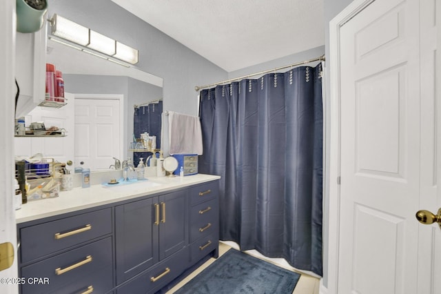 bathroom featuring vanity, curtained shower, and a textured ceiling