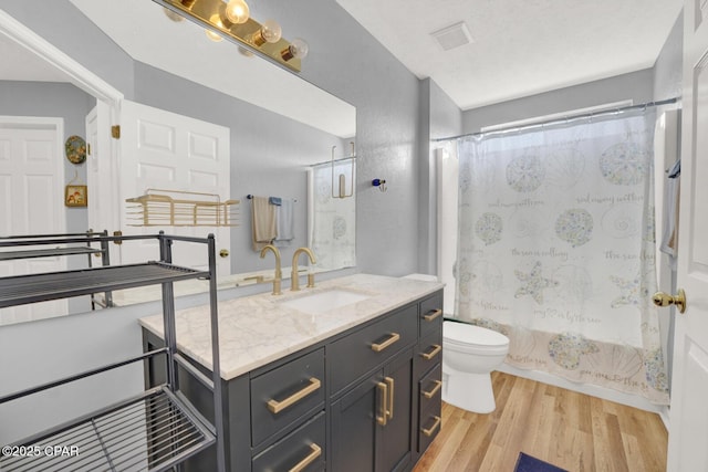 full bathroom featuring vanity, hardwood / wood-style flooring, toilet, and shower / bath combo with shower curtain