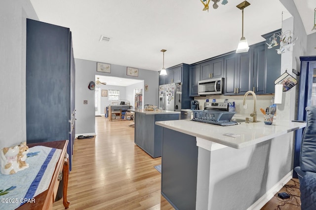 kitchen with pendant lighting, stainless steel appliances, kitchen peninsula, and a kitchen bar