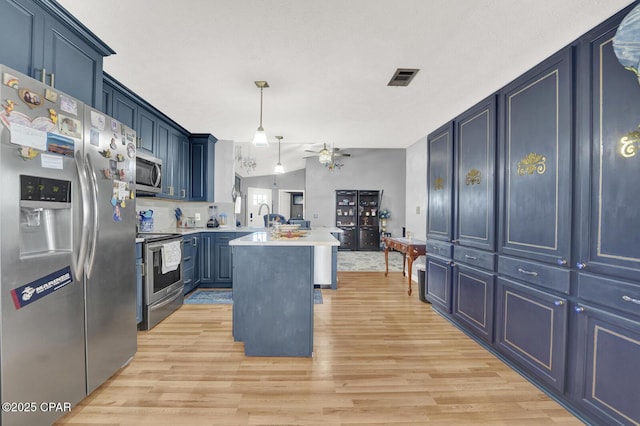 kitchen with a center island, appliances with stainless steel finishes, decorative light fixtures, and blue cabinets