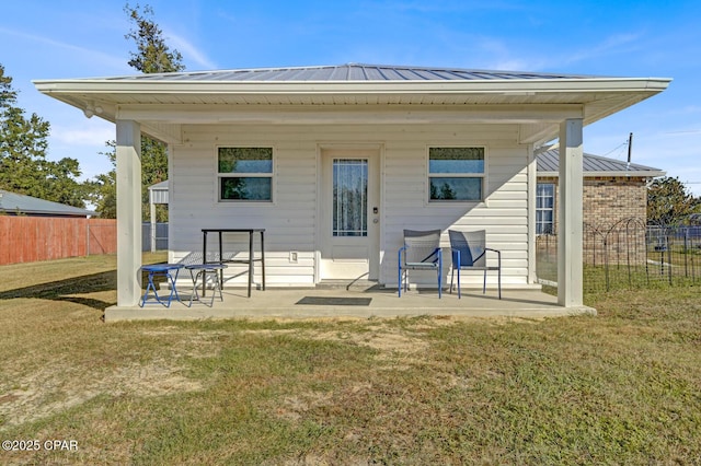 rear view of house featuring a yard and a patio area