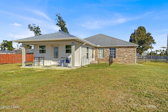 back of property featuring a lawn and a patio