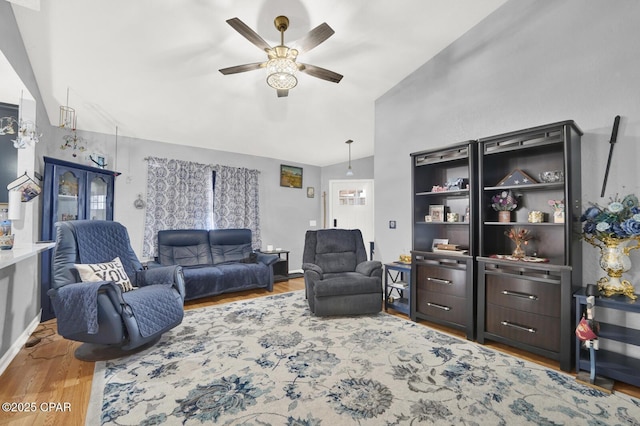 living room featuring ceiling fan, wood-type flooring, and vaulted ceiling