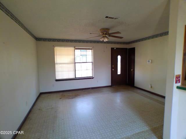 unfurnished room featuring ceiling fan and a textured ceiling