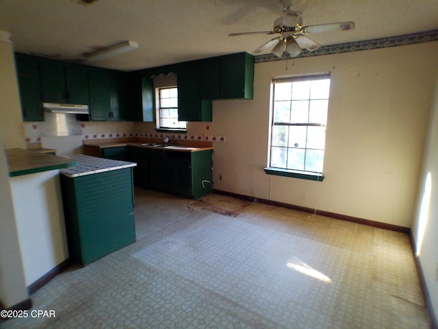 kitchen with ceiling fan, sink, and a textured ceiling