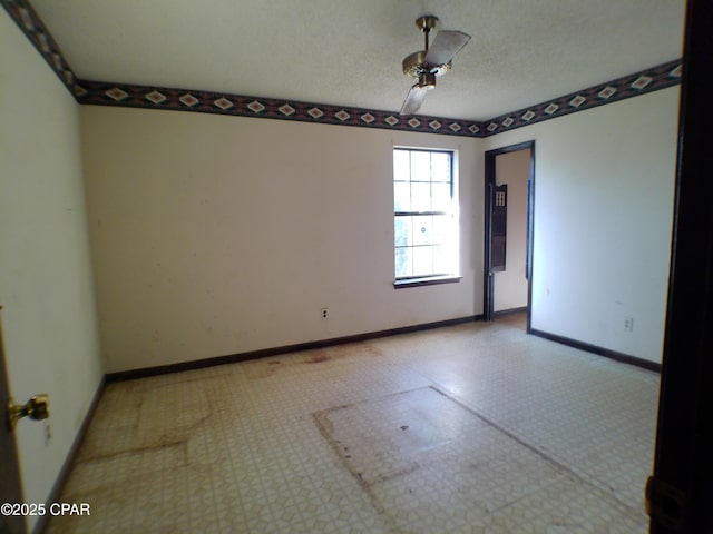 empty room featuring ceiling fan and a textured ceiling