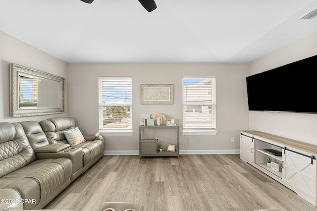 living area with vaulted ceiling, light wood-type flooring, visible vents, and baseboards