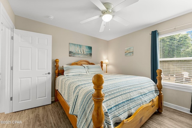 bedroom with ceiling fan, baseboards, and wood finished floors