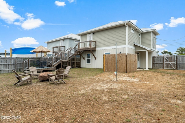 back of house with a fenced backyard, a gate, and stairway