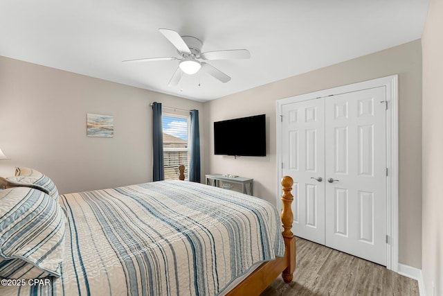 bedroom featuring baseboards, a closet, a ceiling fan, and wood finished floors