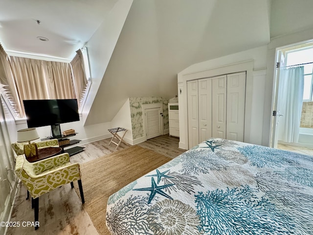 bedroom featuring wood finished floors, a closet, and baseboards