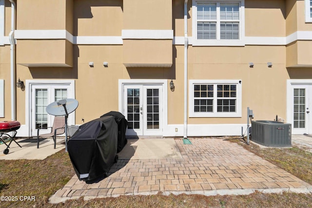 rear view of house featuring french doors, central AC unit, and a patio area