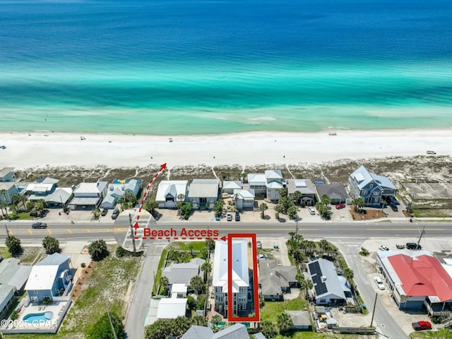 birds eye view of property with a water view, a residential view, and a beach view