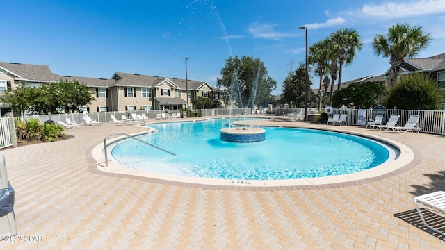 pool with a patio area, a residential view, and fence