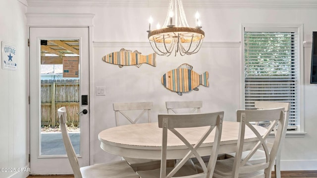 dining room with ornamental molding and an inviting chandelier