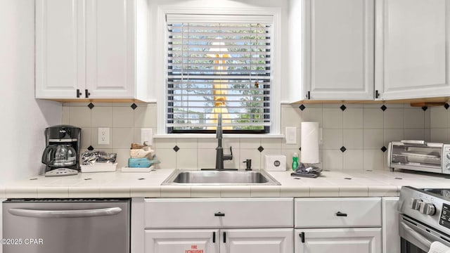 kitchen featuring white cabinetry, sink, tasteful backsplash, and appliances with stainless steel finishes