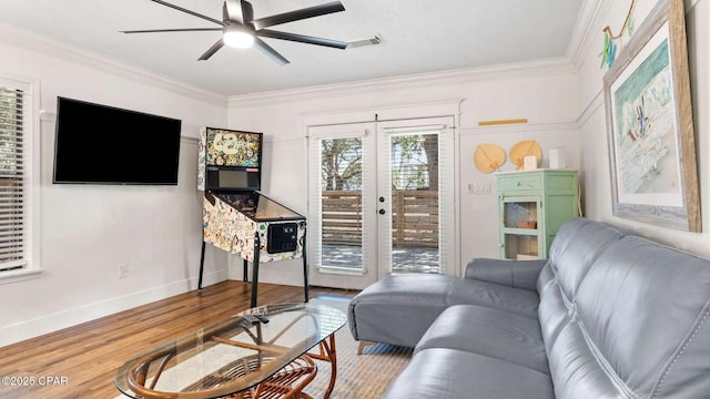 living room with hardwood / wood-style flooring, crown molding, ceiling fan, and french doors