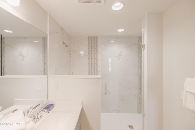 bathroom with vanity and a tile shower