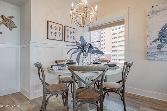 dining space with hardwood / wood-style flooring and a chandelier