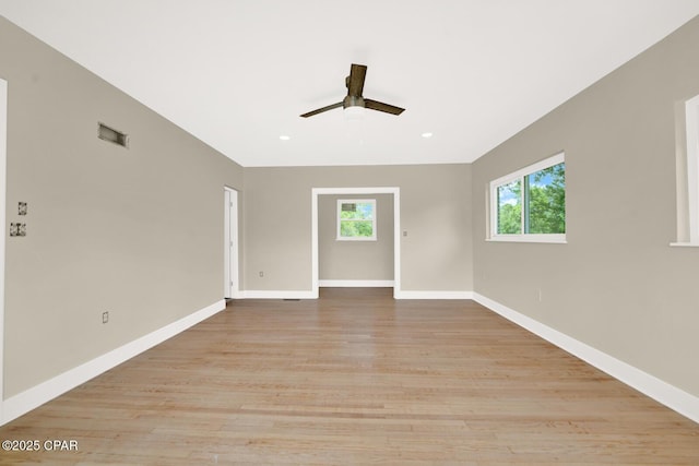 spare room with a wealth of natural light, light hardwood / wood-style floors, and ceiling fan