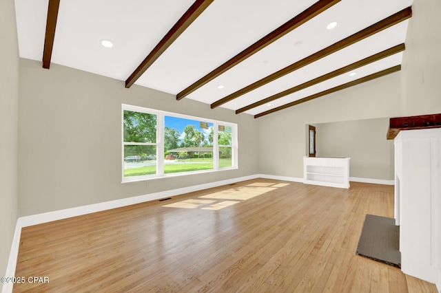 unfurnished living room with lofted ceiling with beams and light hardwood / wood-style flooring