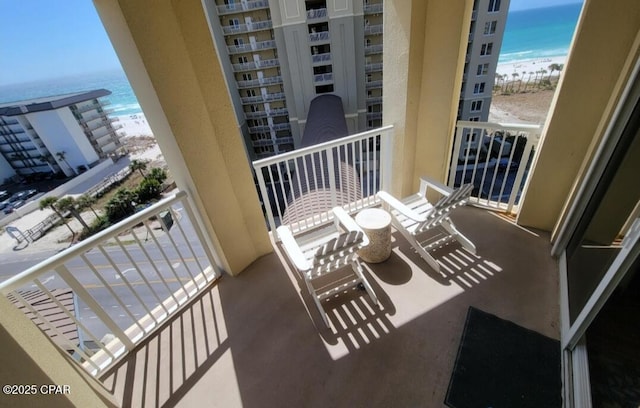 balcony with a beach view and a water view