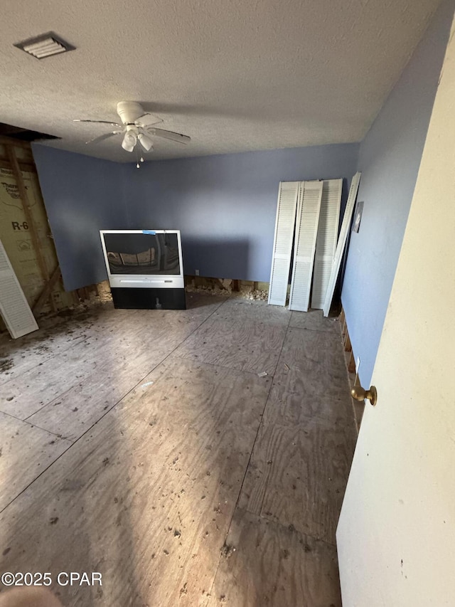 unfurnished room featuring ceiling fan and a textured ceiling