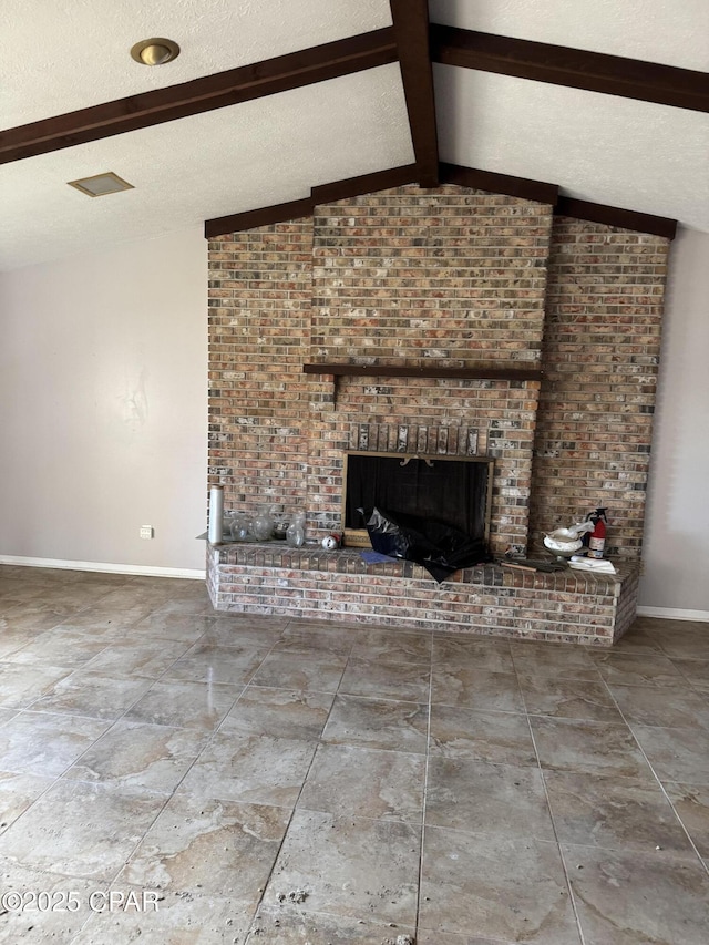 unfurnished living room with a brick fireplace, lofted ceiling with beams, and a textured ceiling