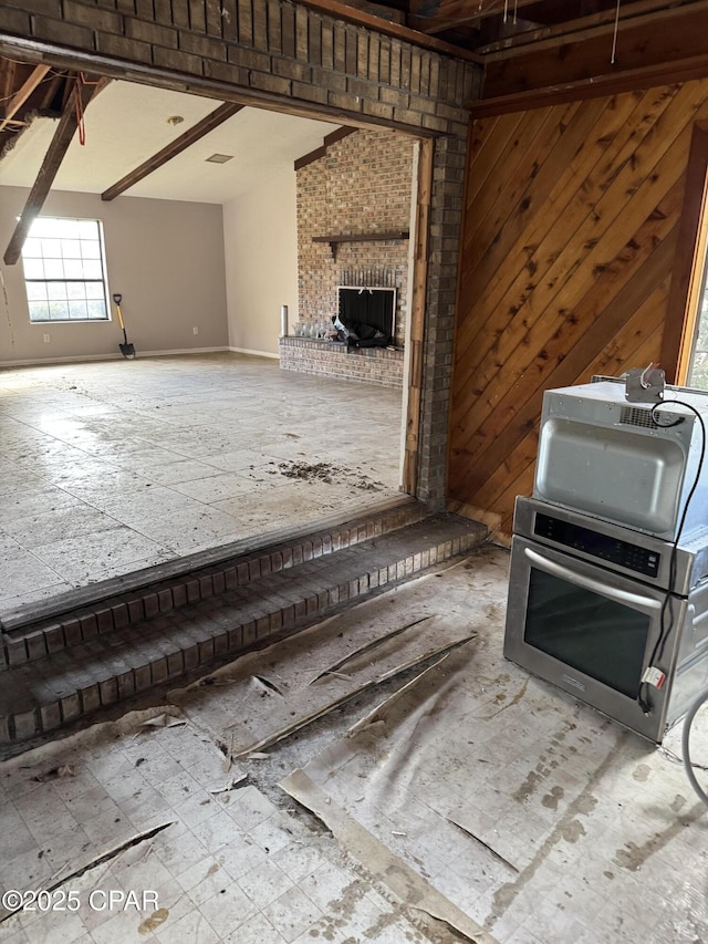 kitchen featuring a fireplace and wood walls