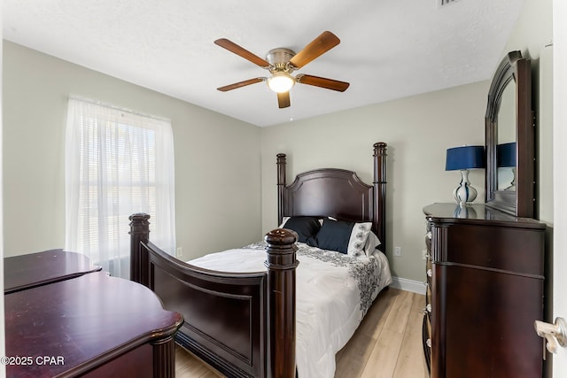 bedroom featuring light wood-style floors, ceiling fan, and baseboards