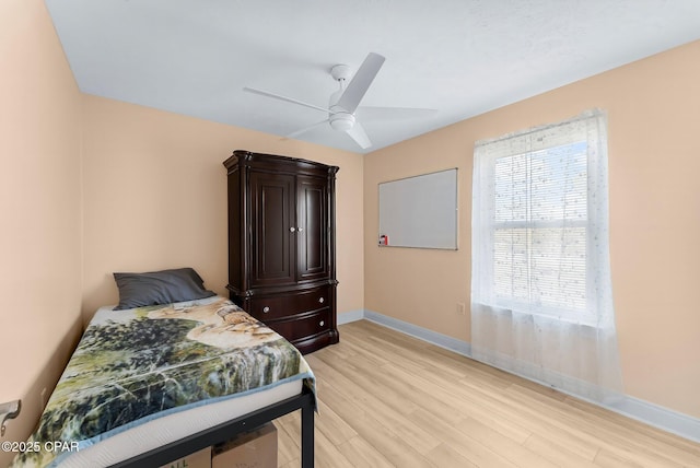 bedroom featuring light wood-style flooring, baseboards, and a ceiling fan