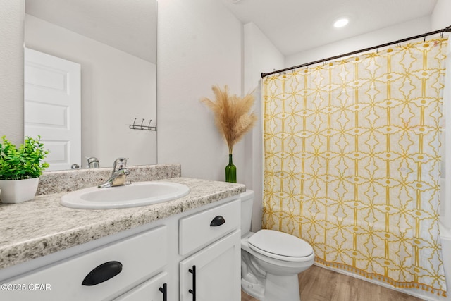 bathroom with hardwood / wood-style flooring, vanity, and toilet