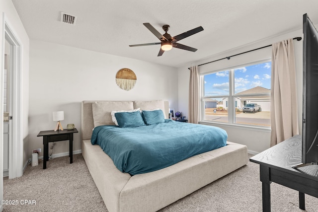 carpeted bedroom with a textured ceiling and ceiling fan