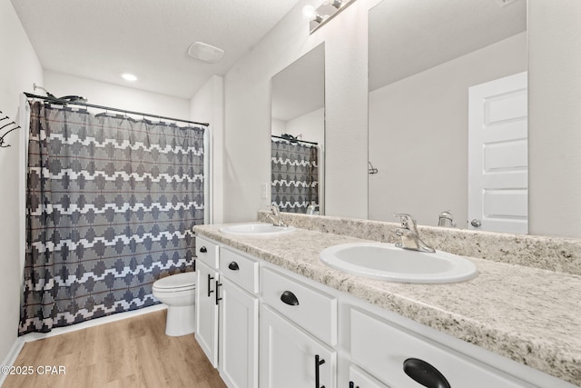 bathroom featuring vanity, hardwood / wood-style flooring, toilet, and walk in shower