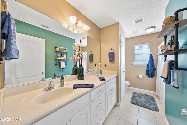 bathroom featuring vanity, a textured ceiling, tile patterned floors, and toilet