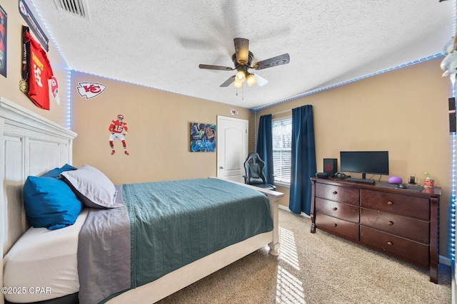 bedroom featuring ceiling fan, light colored carpet, and a textured ceiling