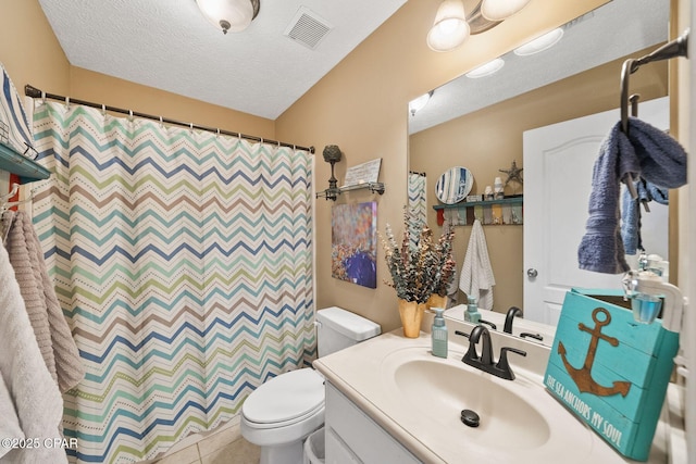 bathroom with a shower with curtain, vanity, a textured ceiling, and toilet