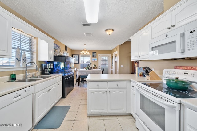 kitchen with white appliances, kitchen peninsula, and white cabinets