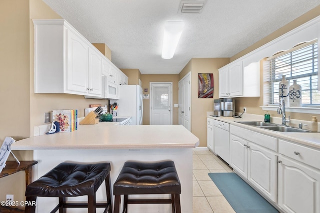 kitchen featuring white appliances, sink, and white cabinets