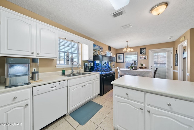 kitchen featuring sink, light tile patterned floors, white dishwasher, pendant lighting, and white cabinets