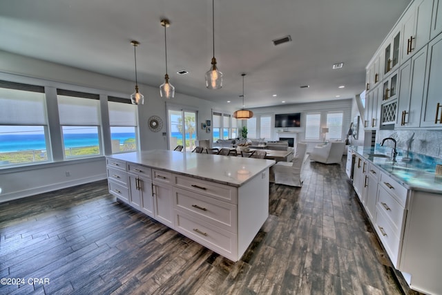 kitchen featuring hanging light fixtures, white cabinetry, and a kitchen island