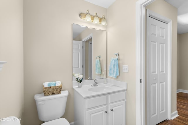 bathroom with vanity, toilet, and wood-type flooring