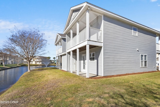 view of side of property featuring a balcony and a lawn