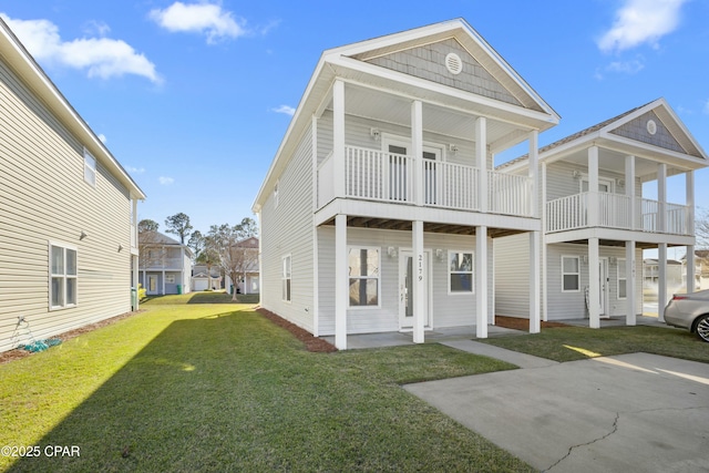 rear view of house featuring a balcony and a lawn