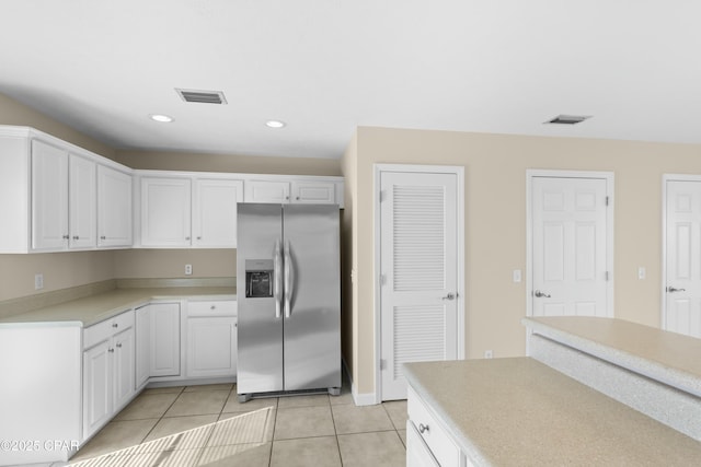 kitchen with white cabinetry, light tile patterned flooring, and stainless steel fridge with ice dispenser