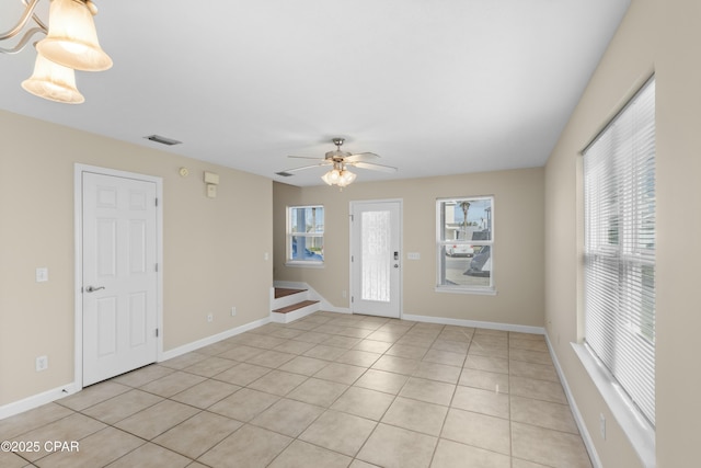 tiled spare room with a wealth of natural light and ceiling fan