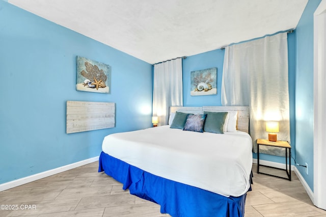 bedroom with baseboards and wood finish floors