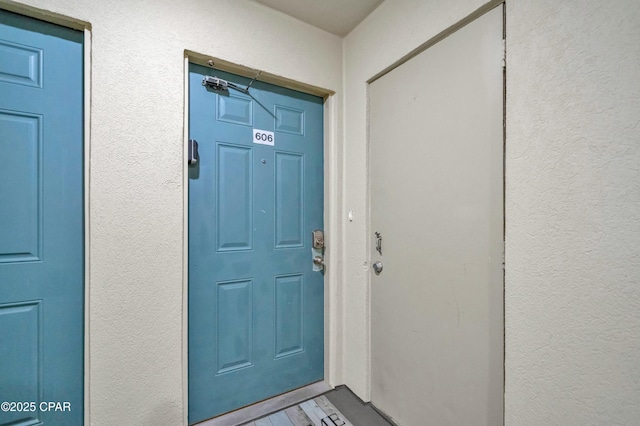 property entrance with stucco siding