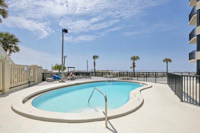 pool with a patio area and fence